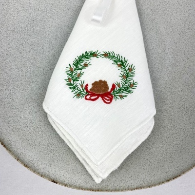 Guardanapo branco bordado com grinalda verde e pinha castanha