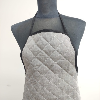 Avental cinza matelassado com tiras pretas num manequim cinza