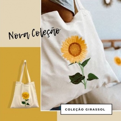 Saco de tecido branco com estampa de girassol amarelo e folhas verdes
