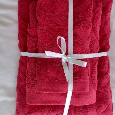 Conjunto de toalhas vermelhas com padrão, amarradas com fita branca
