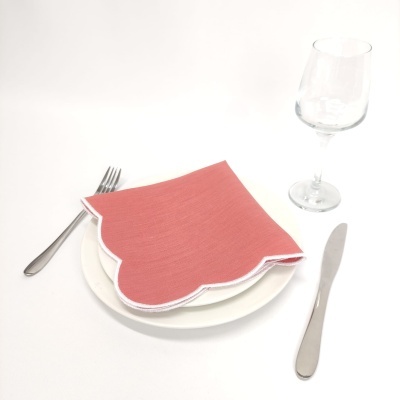 Conjunto de mesa com guardanapo vermelho sobre prato branco e talheres ao lado