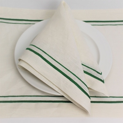 Guardanapo e toalha de mesa brancos com linhas verdes sobre prato branco