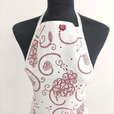 Avental branco com corações vermelhos e arabescos num manequim preto
