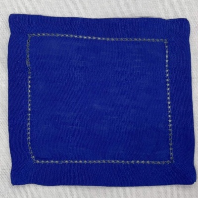 Lenço azul quadrado com costura bege numa superfície branca