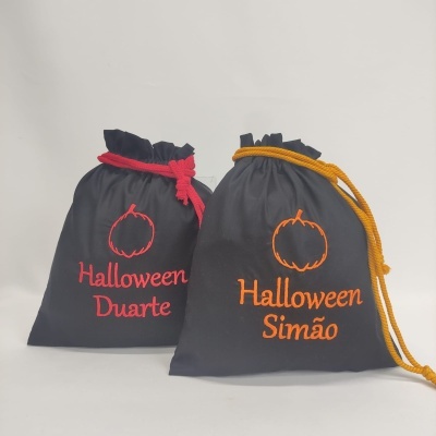 Duas saquetas de tecido preto com bordados de abóboras e texto Halloween