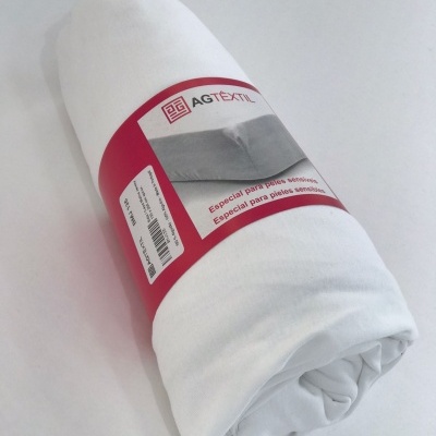 Tecido branco enrolado com etiqueta da marca AGTEX