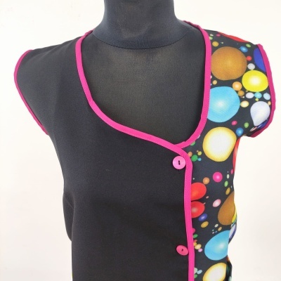 Colete preto sem mangas com padrão colorido e acabamento cor-de-rosa