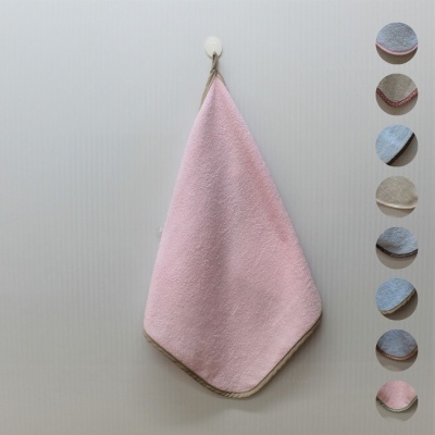 Toalha de mão rosa pendurada com várias amostras circulares de tecido em tons pastel