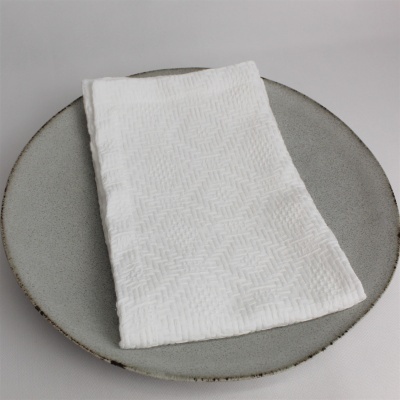 toalha branca texturizada em prato cinza