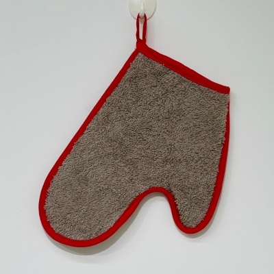 Luva de forno cinza com bordas vermelhas pendurada na parede