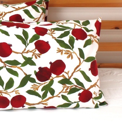Travesseiro com padrão de romãs vermelho, folhas verdes e ramos castanhos