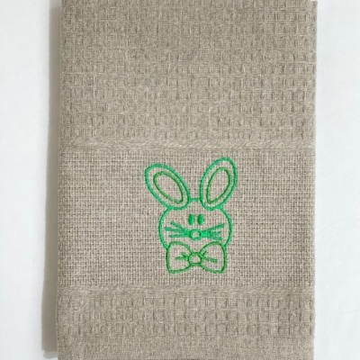 Toalha de tecido bege com bordado verde de coelho