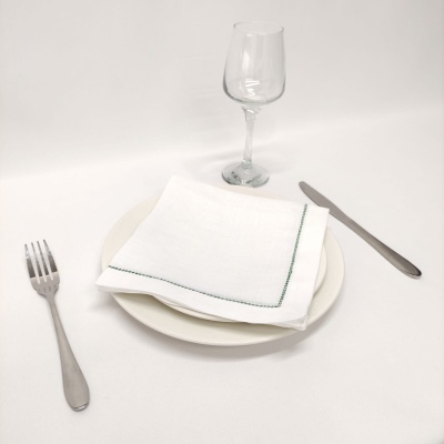 Conjunto de jantar com prato branco, guardanapo, talheres e copo de vinho