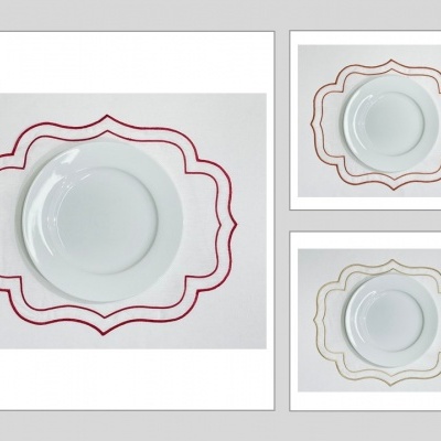 Conjuntos de pratos brancos em toalhas bordadas de diferentes cores