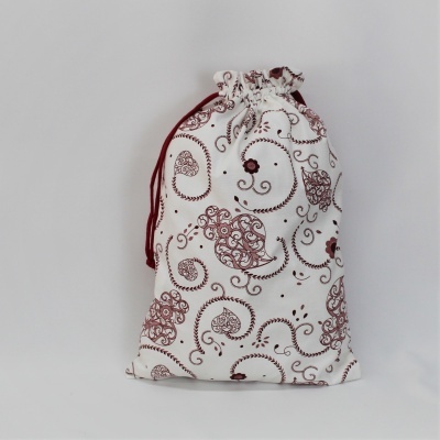 Saco de tecido branco com padrões castanhos e cordão vermelho