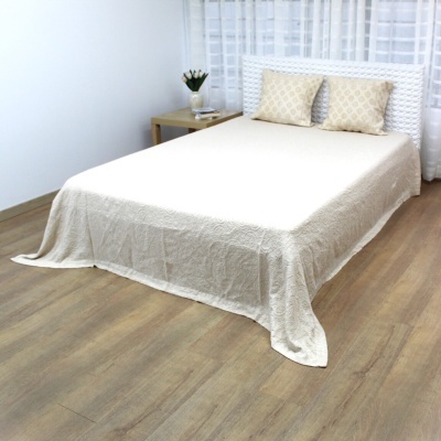 Cama dupla com roupa de cama bege e cabeceira branca trançada