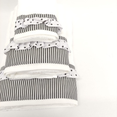 Toalhas empilhadas com padrão às riscas pretas e detalhes de bolinhas pretas