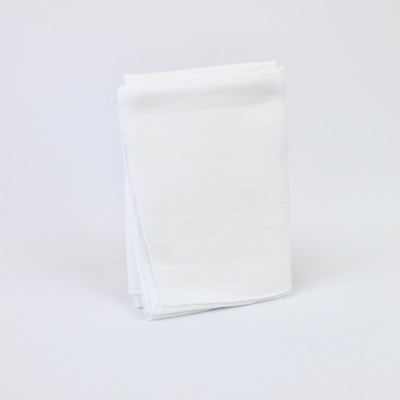 Toalha branca dobrada sobre superfície branca