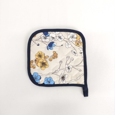 Pega para cozinha com padrão floral azul e amarelo em fundo bege com borda preta