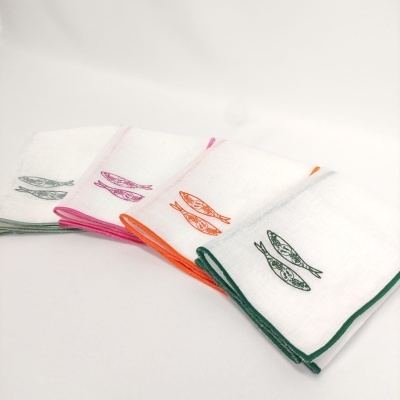 Quatro panos de cozinha brancos com bordas coloridas e estampas de peixes.