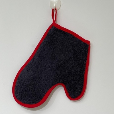 Luvas de forno preto com borda vermelha penduradas na parede