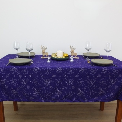 Mesa decorada com toalha roxa e itens de jantar e decoração natalina