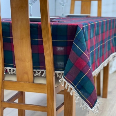 Mesa de jantar com toalha xadrez colorida e cadeiras de madeira