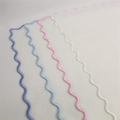 Tecidos brancos com bordas onduladas coloridas em azul, rosa e branco