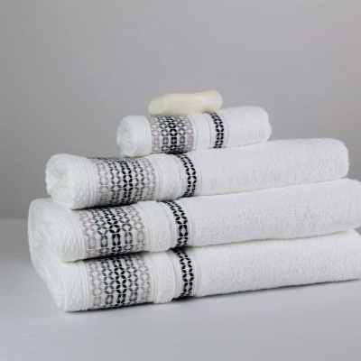 Conjunto de toalhas brancas com faixas cinza e preta empilhadas sobre superfície branca