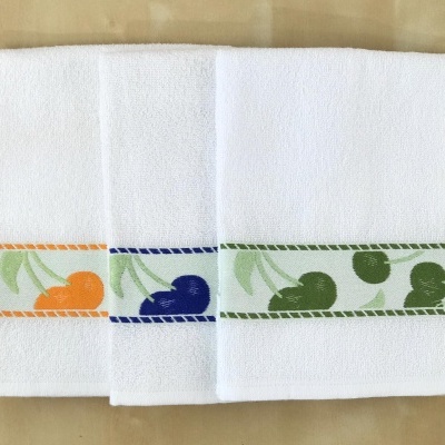 três toalhas brancas com estampas de cerejas em laranja, azul e verde