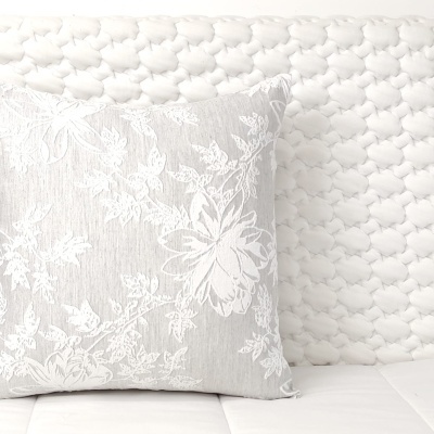 Almofada cinza claro com padrão floral branco e superfície branca acolchoada
