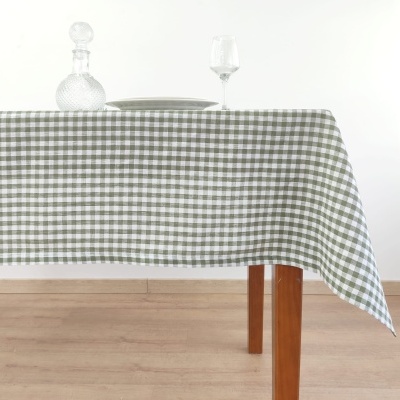 Mesa com toalha xadrez verde e branco, garrafa de vidro, prato e taça de vinho