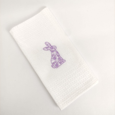 Toalha branca com bordado roxo de coelho