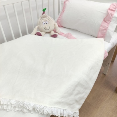 Cama de bebé branca com roupa de cama rosa e branca e peluche