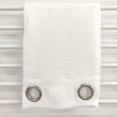 Toalha branca com ilhóses prateados pendurada em barras brancas