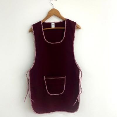 Avental bordô com bordas xadrez pendurado num cabide