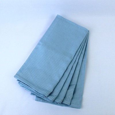 Toalha de cozinha azul clara dobrada com padrão de pequenos quadrados