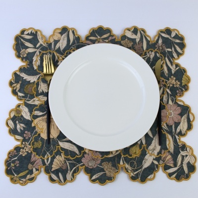 Jogo americano floral com prato branco, garfo e faca dourados