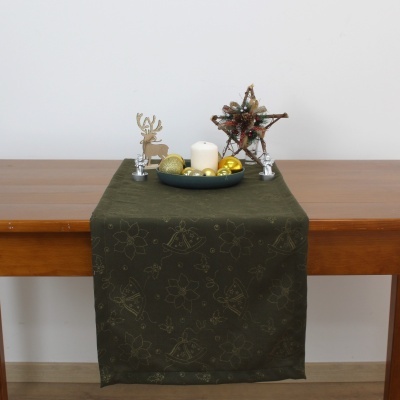 Caminho de mesa verde com decoração natalícia sobre mesa de madeira