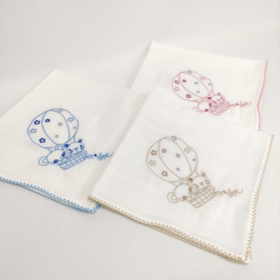 Três panos de tecido branco bordados com balões de ar quente e ursinhos, com bordas coloridas