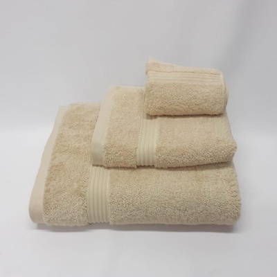 Conjunto de toalhas bege de diferentes tamanhos empilhadas em fundo branco