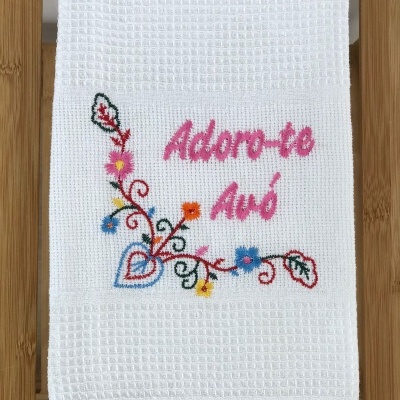 Toalha branca com bordado colorido e texto em rosa 'Adoro-te Avó'