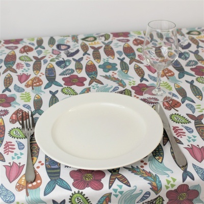 Toalha de mesa colorida com prato branco, talheres e copo