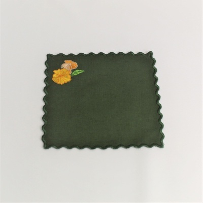 Guardanapo verde com borda ondulada e bordado de flores amarelas e laranja