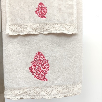 Toalhas bege com bordado vermelho e renda na borda