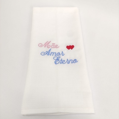Toalha branca bordada com as palavras 'Mãe Amor Eterno' e dois corações vermelhos