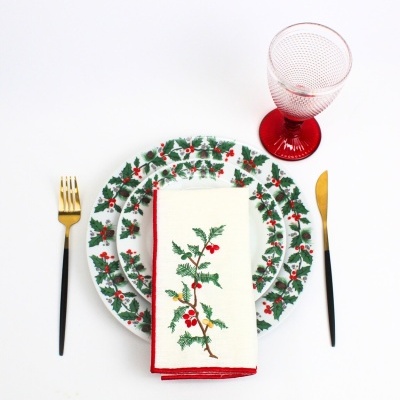 Conjunto de prato, guardanapo bordado, talheres e copo decorados com tema de azevinho