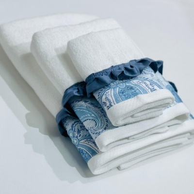 Toalhas brancas com detalhes azuis e padrão paisley empilhadas