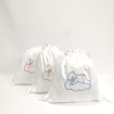 Saquinhos de tecido branco com ursinhos bordados em azul, castanho e rosa