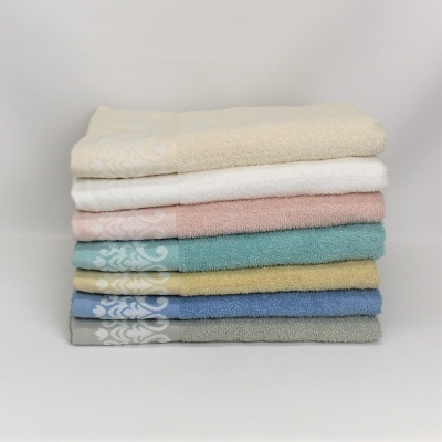 Conjunto de sete toalhas coloridas empilhadas com padrão decorativo branco